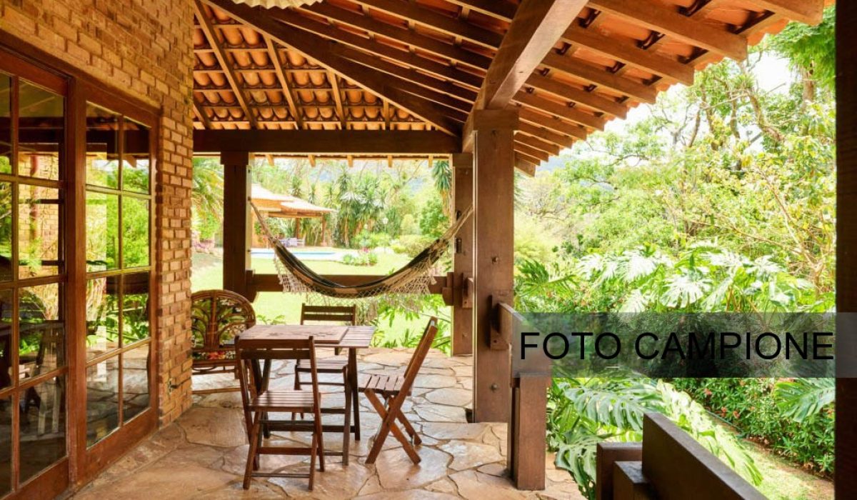Shot of a holiday home veranda with small wooden coffee table and chairs and hammock at the back